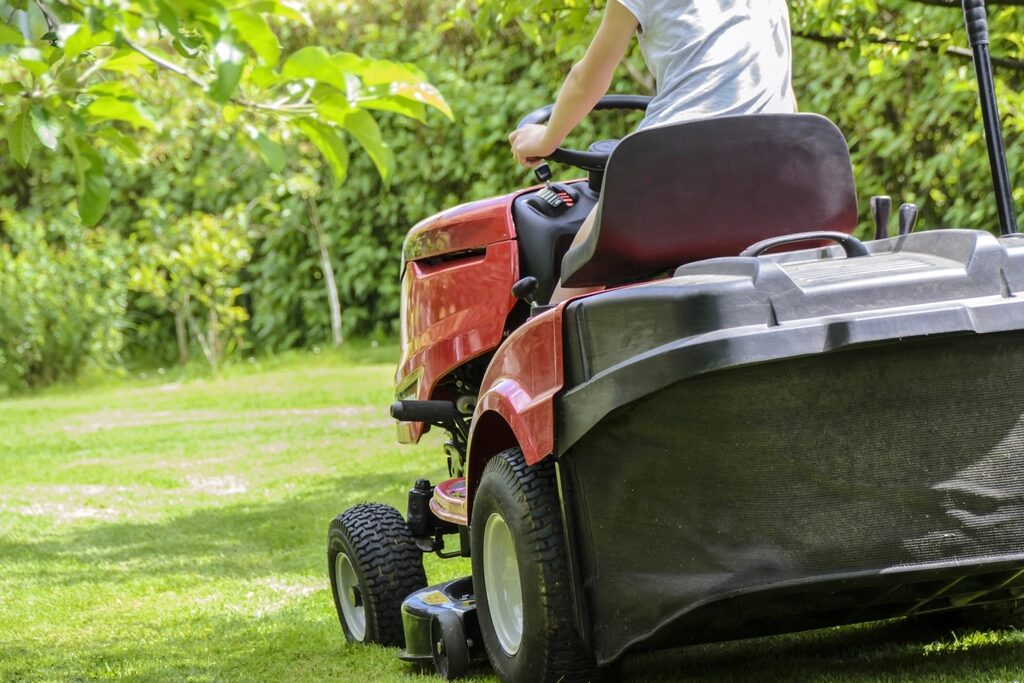 Crew member mowing with a riding mower